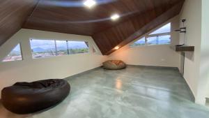 a attic room with two bean bags and windows at Triplex novo em Matinhos litoral Paraná in Matinhos