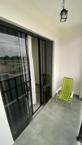 a room with a balcony with a chair and a window at Triplex novo em Matinhos litoral Paraná in Matinhos
