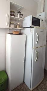 Elle comprend un réfrigérateur blanc et un four micro-ondes. dans l'établissement Calido Departamento en Belgrano, à Buenos Aires