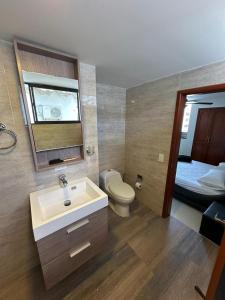 a bathroom with a sink and a toilet and a bed at Apartamento frente al MAR Rodadero - Gaira TACOA 6 a 8 personas in Rodadero