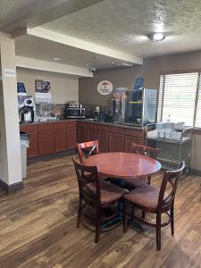 a room with a table and chairs and a kitchen at Super 8 by Wyndham Hastings in Hastings