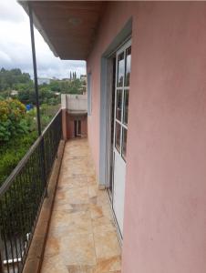 een balkon van een roze gebouw met een raam bij Residencial GM in San Vicente