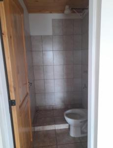 a bathroom with a toilet and a tiled floor at Residencial GM in San Vicente