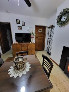 a living room with a table and a television at La Estrella de Gredos in Guisando