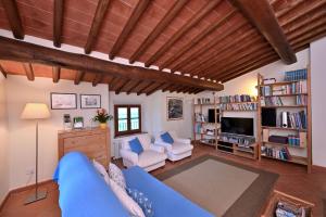 a living room with a blue couch and a tv at Villa Claudia in Cavriglia