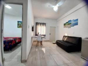 uma sala de estar com um sofá preto e uma cama em Mar.6: spacious 1 room, 2 AC, near Airport and Stella Maris beach em Salvador