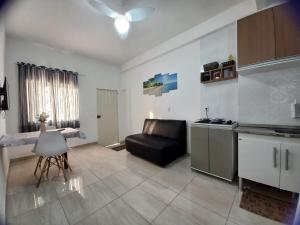 uma cozinha e sala de estar com um sofá e uma mesa em Mar.6: spacious 1 room, 2 AC, near Airport and Stella Maris beach em Salvador