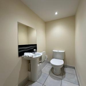 a bathroom with a toilet and a sink at Canary Wharf Apartments in London