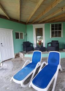 two blue and white chairs sitting on a patio at Beachfront Cozy Apt in Gros Islet