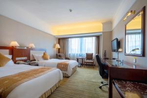 a hotel room with two beds and a desk at Sunshine Holiday Hotel Fuzhou in Fuzhou