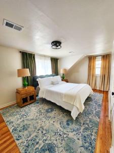 a bedroom with a large bed and a blue rug at Chic Spacious Apt Near Attractions/Food/EWR/NYC in West Orange