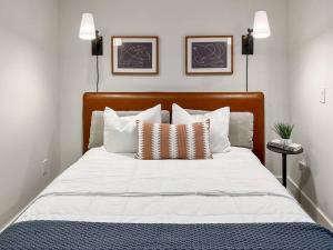 a bedroom with a bed with white sheets and pillows at Leo's Bear Lake Hideaway in Kalkaska