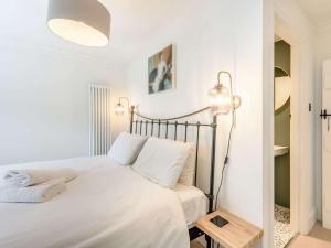 een witte slaapkamer met een bed en een lamp bij 4 Bed in Hawes 89363 in Hawes