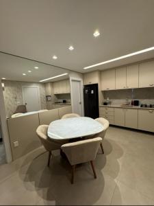 a kitchen with a table and chairs in a room at Flat próximo ao Shopping Campo Grande in Campo Grande