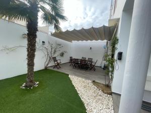 a patio with a palm tree and a table and chairs at Donde habita el olvido in Baeza
