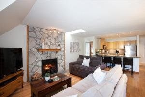 a living room with a couch and a fireplace at Gleneagle 29 - Townhome near Golf Course with Balcony, BBQ - Whistler Platinum in Whistler