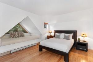 a white bedroom with a bed and a couch at Gleneagle 29 - Townhome near Golf Course with Balcony, BBQ - Whistler Platinum in Whistler