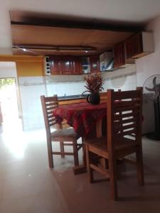 チレシトにあるDepartamento Villa Auroritaのキッチン(テーブル、椅子、花瓶付)