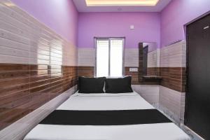 a room with purple walls and a bed in it at Super OYO PPS NEST Guest House in Kolkata