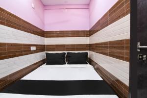 a bed in a room with wood paneling at Super OYO PPS NEST Guest House in Kolkata