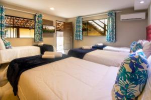 a bedroom with two beds and two windows at Hotel Barra da Lagoa by Latitud Hoteles in Búzios +110 photos