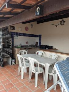 聖佩德羅－達阿爾德亞的住宿－Região dos Lagos - casa para temporada，一间带桌子和白色椅子的用餐室