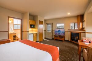 a bedroom with a bed and a tv and a fireplace at Inn at Cannon Beach in Cannon Beach