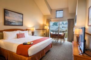 a hotel room with a bed and a desk and a table at Inn at Cannon Beach in Cannon Beach +38 photos