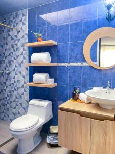 Baño de azulejos azules con aseo y lavamanos en Apto tipo loft ubicado en Normandia, en Bogotá