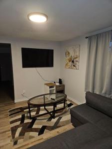 a living room with a couch and a table at Cozy and quiet apartment in Sudbury