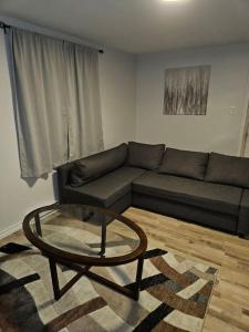 Cozy and quiet apartment في سودبيري: غرفة معيشة مع أريكة وطاولة زجاجية