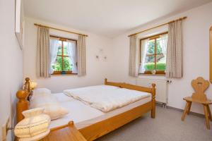 1 dormitorio con 1 cama y 2 ventanas en Ferienwohnung Bettina, en Reit im Winkl
