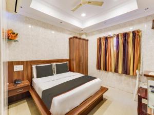 ein Schlafzimmer mit einem Bett in einem Zimmer in der Unterkunft OYO Park Royal in Chennai