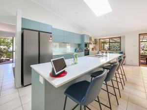 a kitchen with a island with a laptop on a counter at Bokarina Family Pet Friendly Holiday Home in Kawana Waters