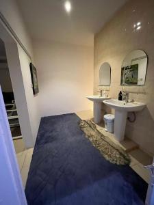 Baño con 2 lavabos y alfombra azul en مزرعة واستراحة درب التوت, en Riad
