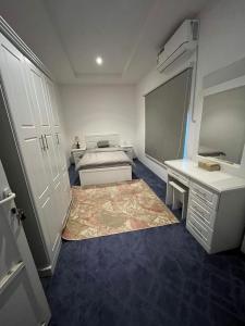 1 dormitorio con cama, escritorio y alfombra en مزرعة واستراحة درب التوت, en Riad