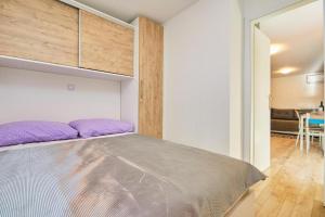a bedroom with a large bed with purple pillows at Apartments with parking space Babino Polje, Mljet - 22319 in Babino Polje