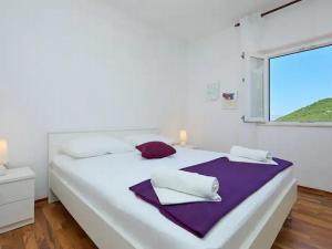 ein weißes Schlafzimmer mit einem großen Bett und einem Fenster in der Unterkunft Apartments by the sea Prozurska Luka, Mljet - 22338 in Prožura