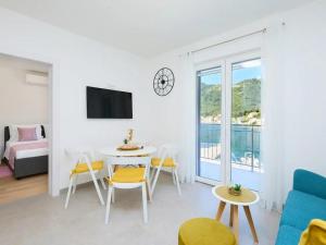 una sala de estar blanca con mesa y sillas en Apartments by the sea Okuklje, Mljet - 22341, en Okuklje