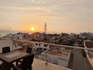 uma varanda com vista para a cidade ao pôr-do-sol em Apartamento exclusivo Familiar 306 em San Bartolo