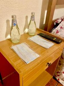 dos botellas de vidrio sentadas en una mesa con un teclado en Hotel Olmos en Vicuña