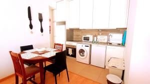 a small kitchen with a table and a dining room at No centro, junto à Avenida da Liberdade - 1 Drt in Fundão