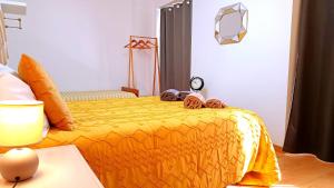 una camera da letto con un letto e un piumone giallo di No centro, junto à Avenida da Liberdade - 1 Drt a Fundão