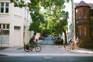 two people riding bikes down a city street at Live in the heart of Surry Hills - walk to City in Sydney