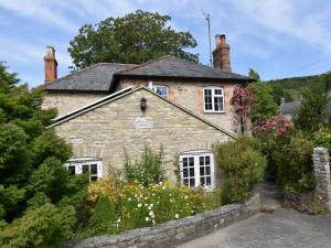 an old stone house with flowers in front of it at 3 Bed in Portesham DC181 in Portesham