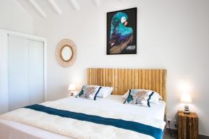 a bedroom with a white bed with a wooden headboard at Beautiful suite S12 with pool and sea view in Cul de Sac