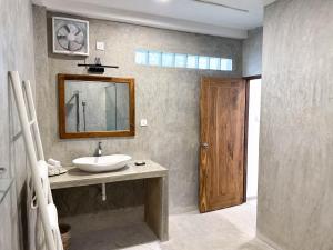 uma casa de banho com um lavatório e um espelho em We Escape em Weligama