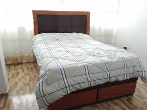 ein großes Bett in einem Zimmer mit Holzboden in der Unterkunft Departamento centrico de lujo en Huancayo in Huancayo