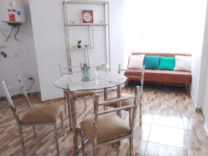einen Tisch und Stühle im Wohnzimmer mit Sofa in der Unterkunft Departamento centrico de lujo en Huancayo in Huancayo