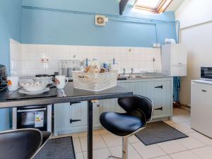 a kitchen with blue walls and a counter and chairs at 1 bed property in Brynteg 81354 in Llanwenog